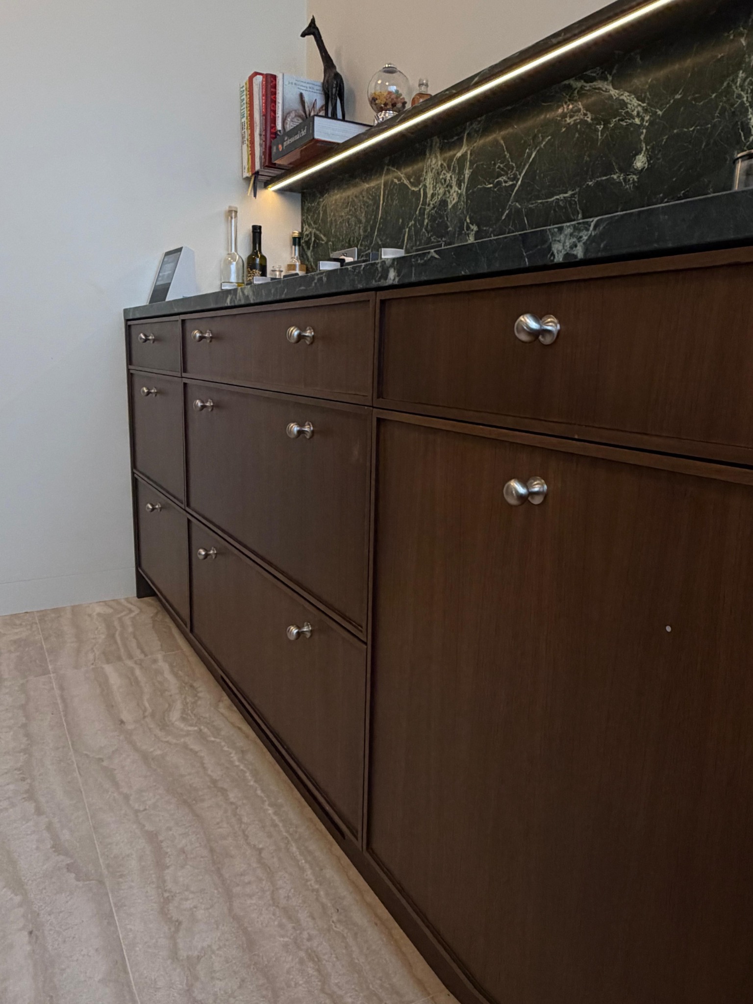 Detail of dark timber kitchen cabinets with metal handles
