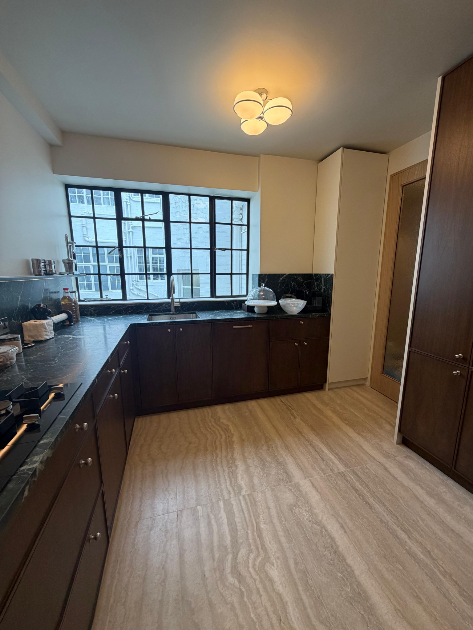 Dark kitchen cabinets beneath a large window
