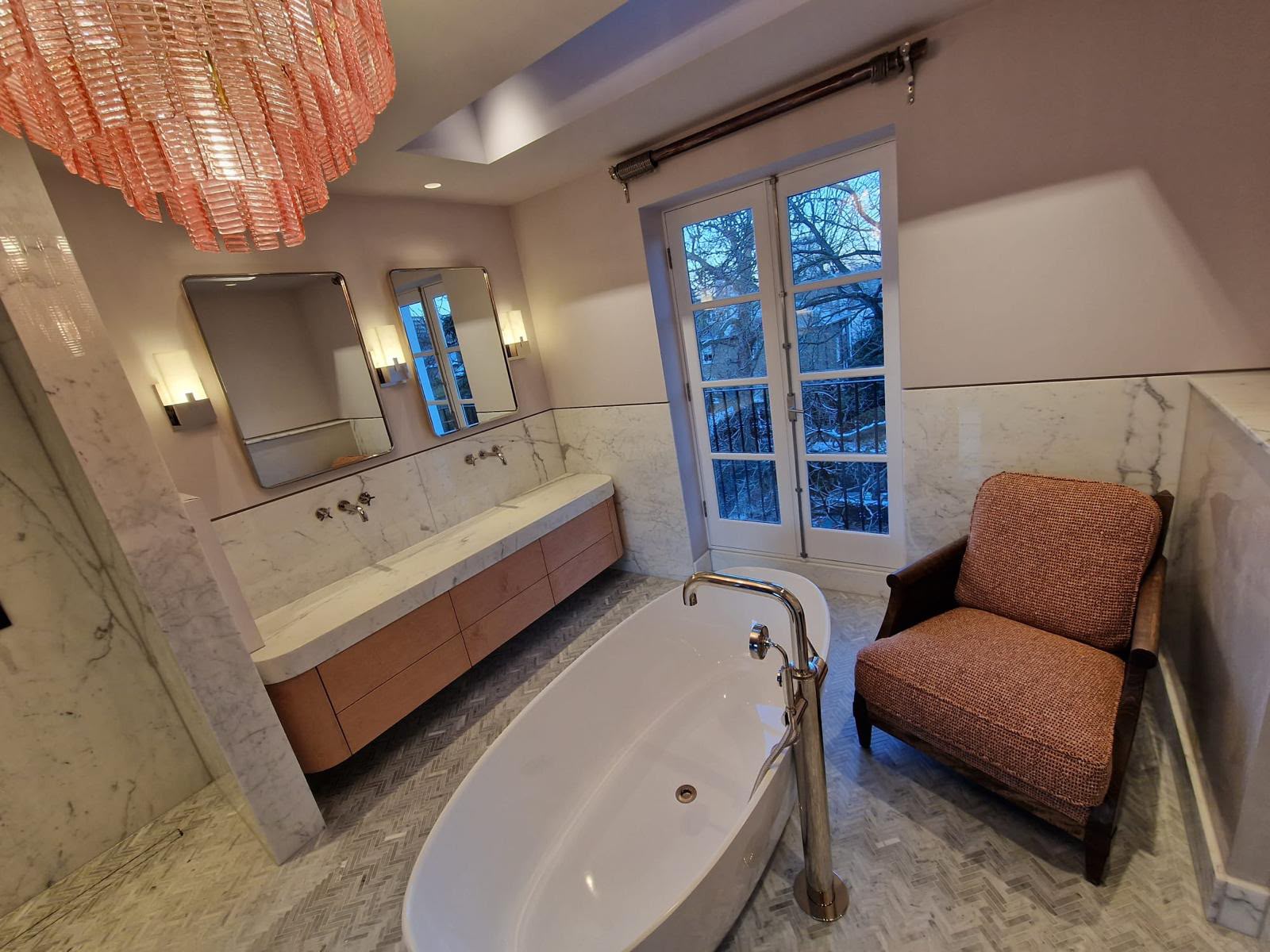 Long timber vanity with drawers beneath a double basin in a marble bathroom