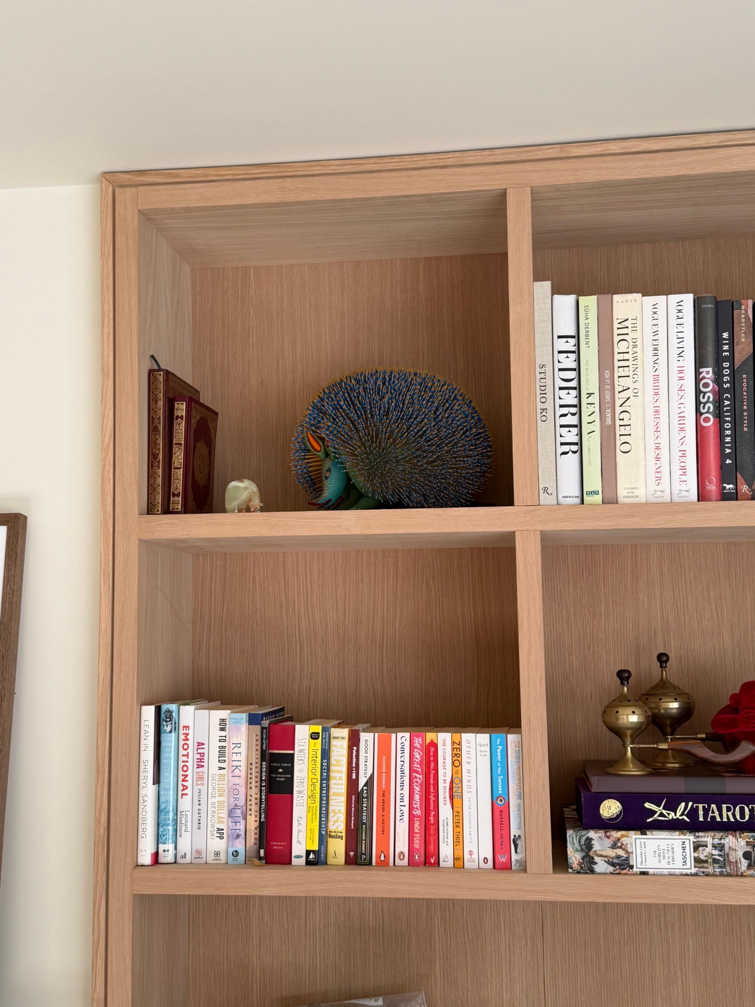 Timber bookshelves containing books and decorative objects
