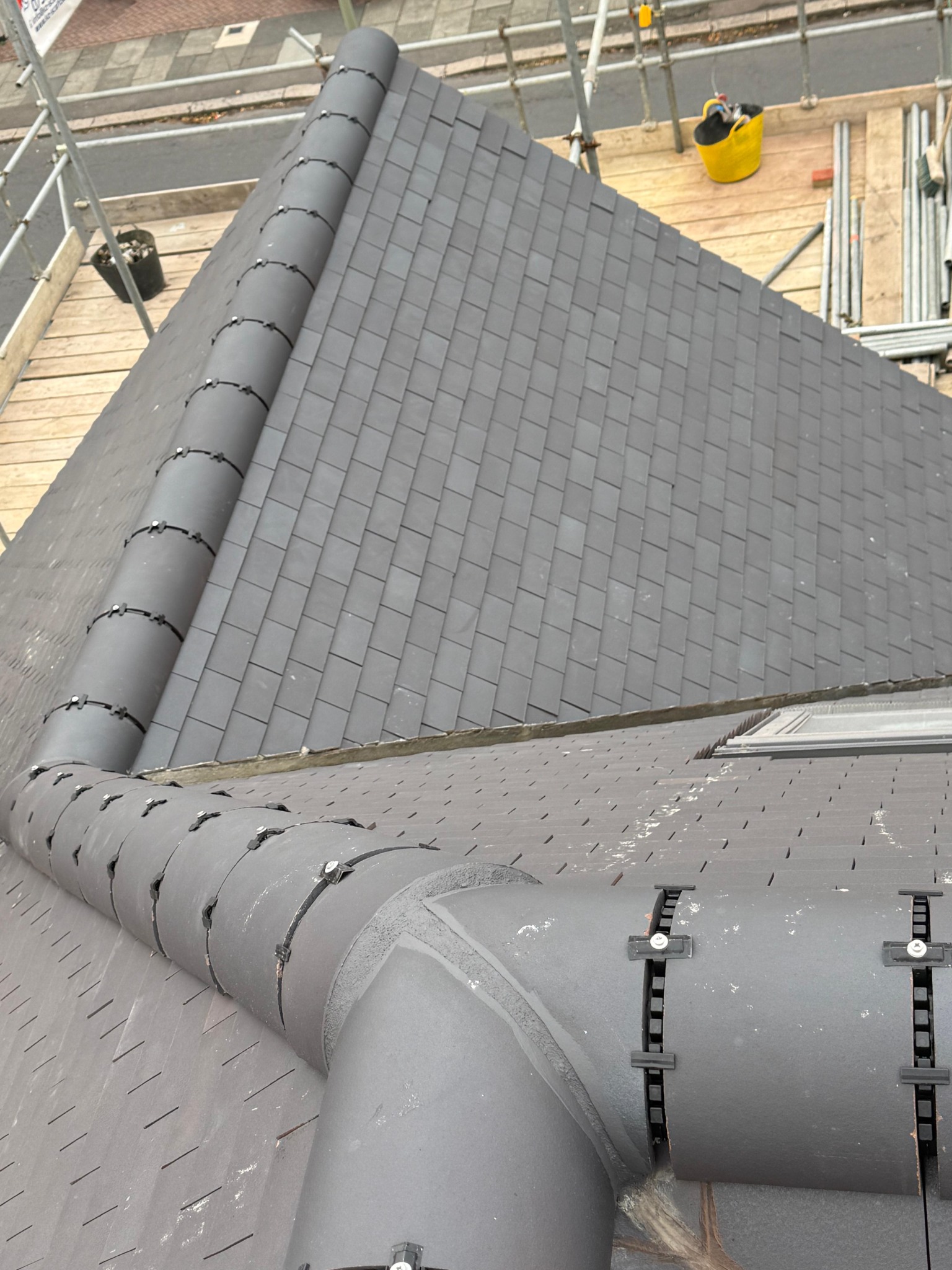 Close view of intersecting tiled roof slopes and ridge tiles
