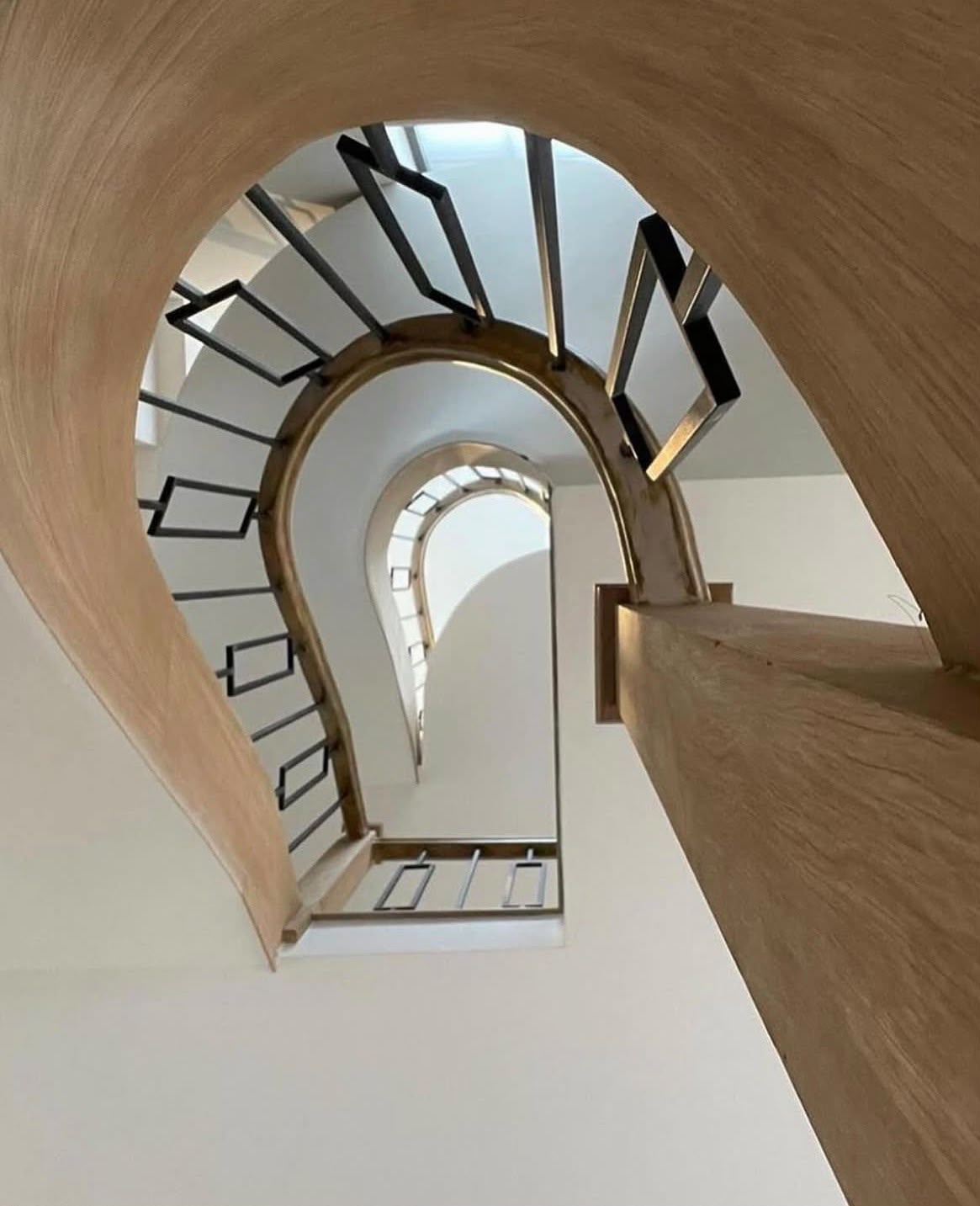 View up through successive curved timber stair flights