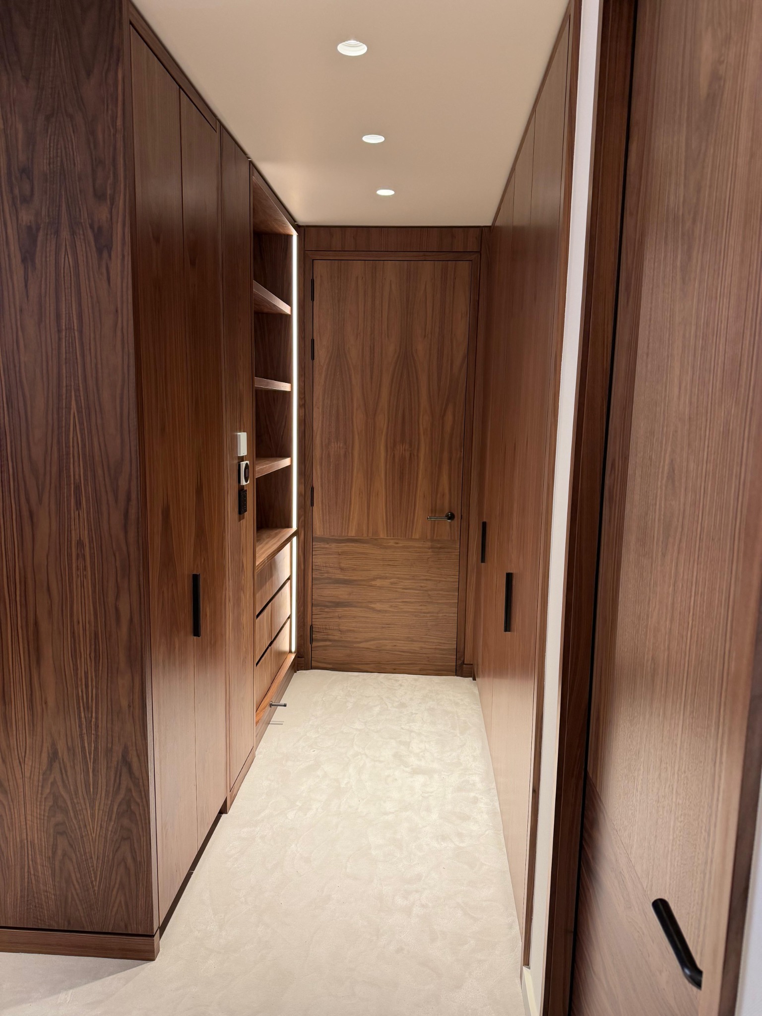 Walkway between full-height timber wardrobes